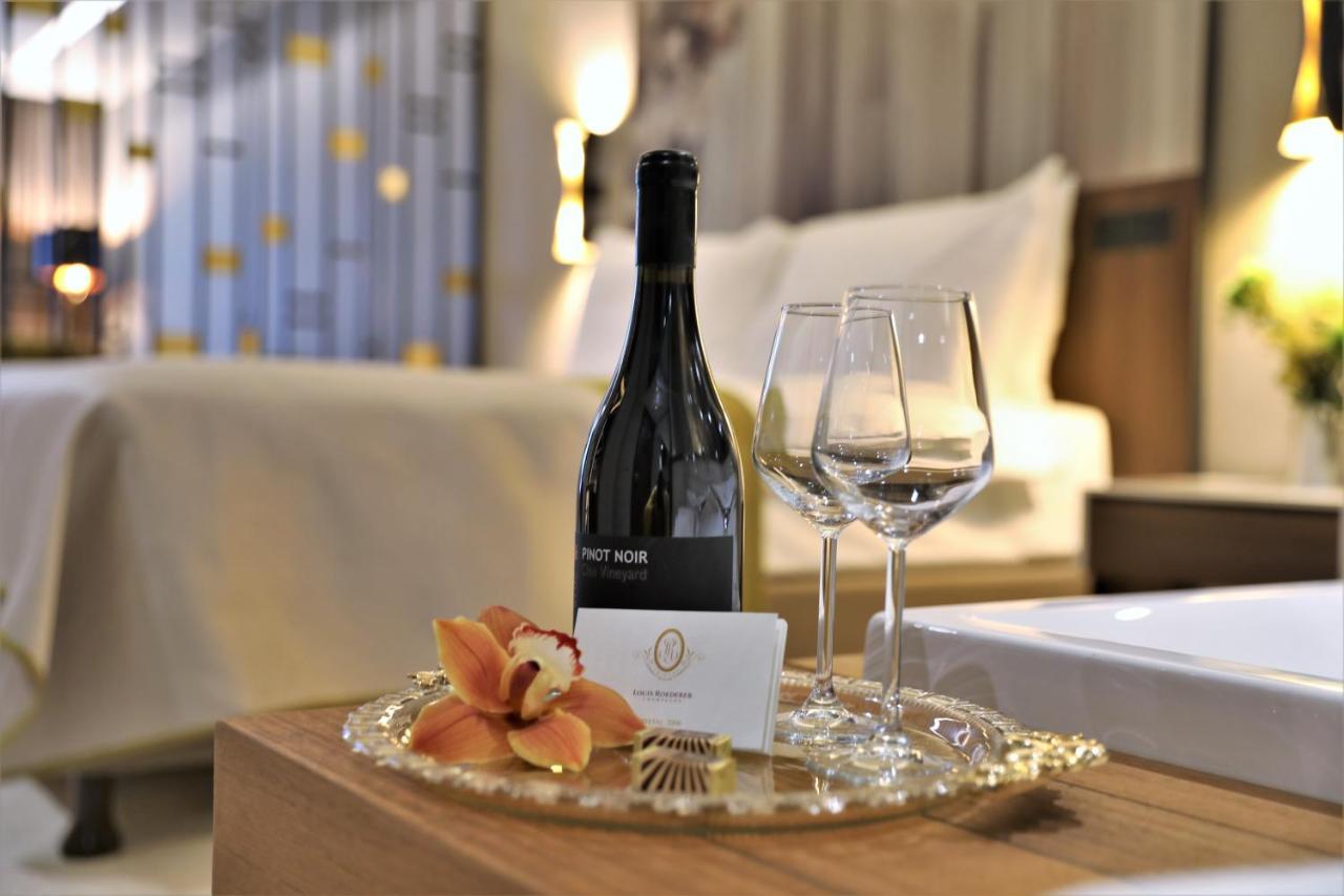 Limak Skopje Luxury Hotel Exterior photo A bottle of wine and a glass